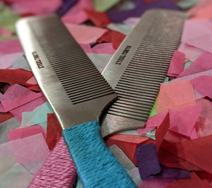 Two combs one with pink and the other a blue handle. 
