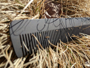 A steeltooth new standard comb with a deep red/brown finish on it in some dead grass.  